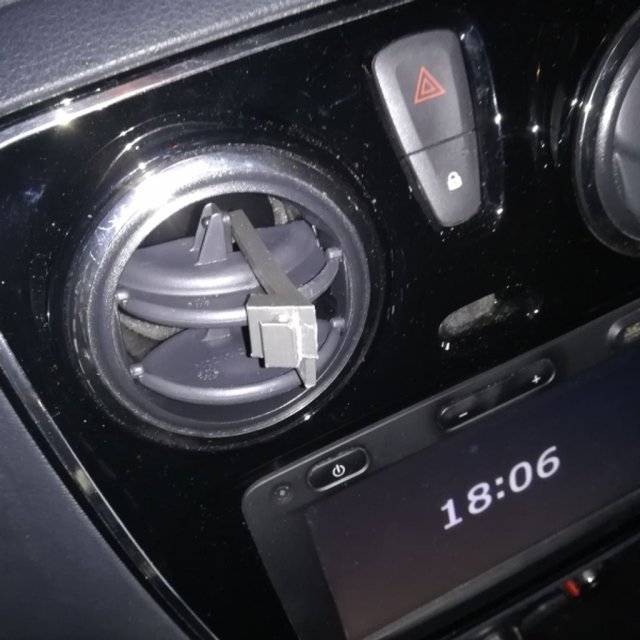 Phone holder clip on ventilation flap of a car — source image